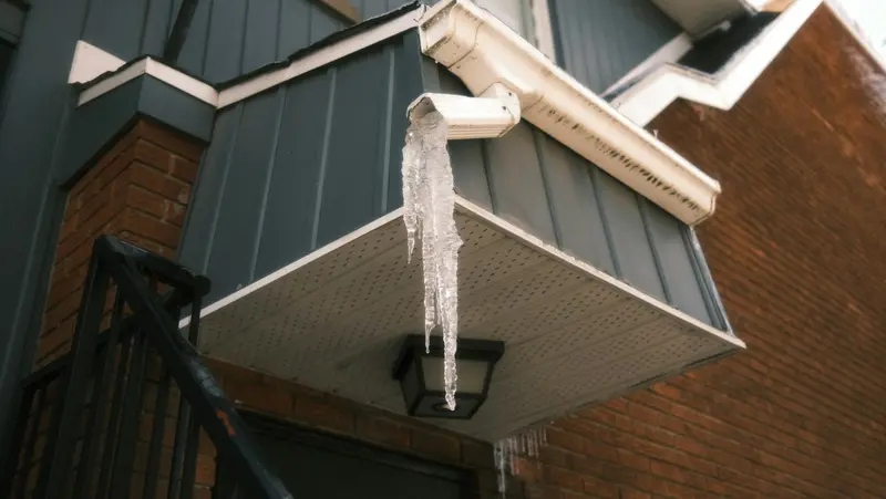 Icicles hanging from a downspout and eavestrough in winter