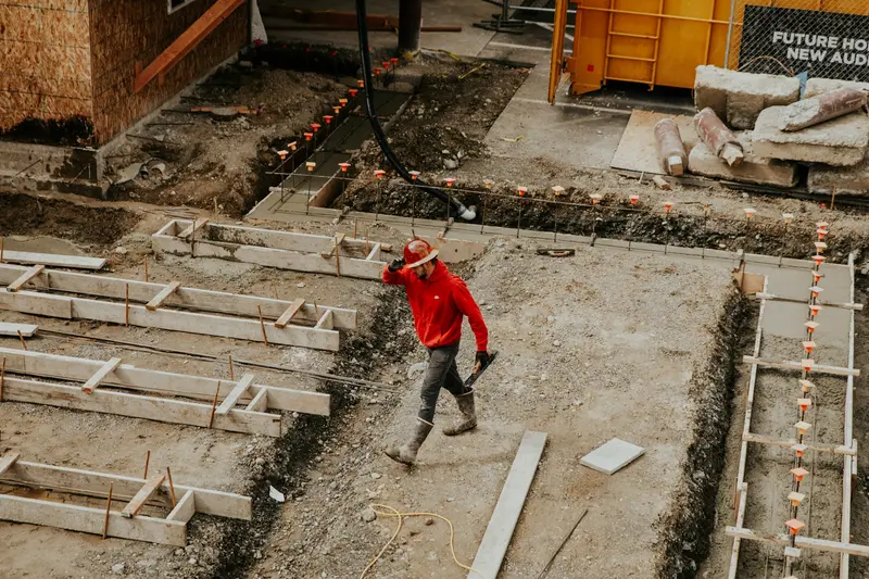 Aerial view of a house foundation under construction with a worker on site