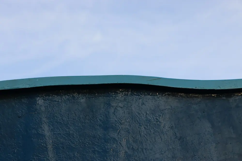 Black waterproof coating applied to the top of a concrete foundation wall