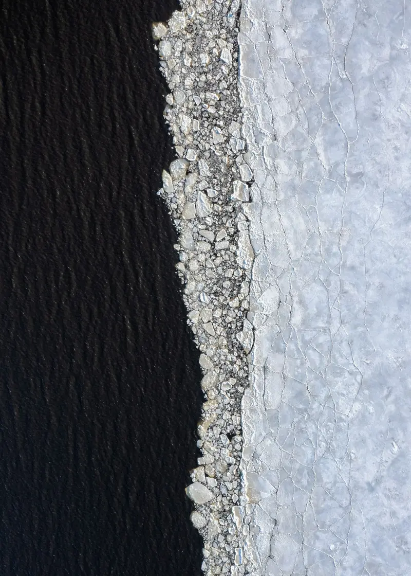 Black waterproofing membrane meeting a bed of white crushed stone