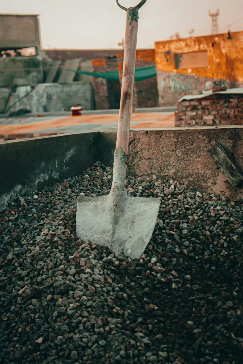 Shovel standing in a bed of clear crushed stone